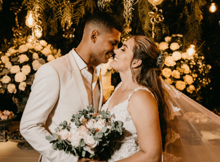Ehepaar auf der Hochzeit mit einem Blumenstrauß in der Hand vor dem Altar kurz vor dem Kuss.